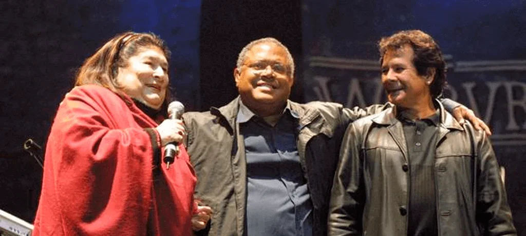 Trío de troveros cantando juntos en un escenario
